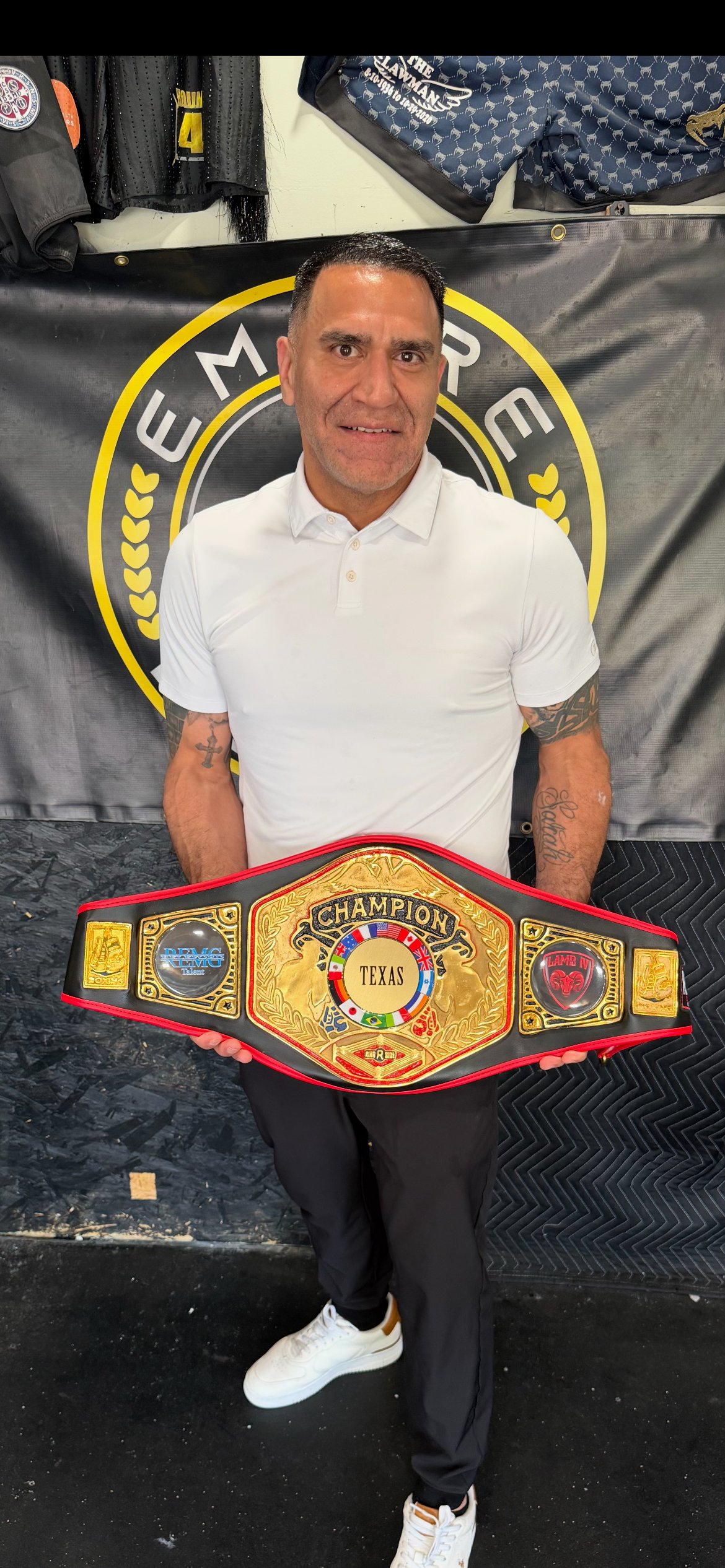 Coach Francisco Rodriguez holding the Texas Cruiserweight Championship belt at Empire Boxing DFW gym in Plano Texas